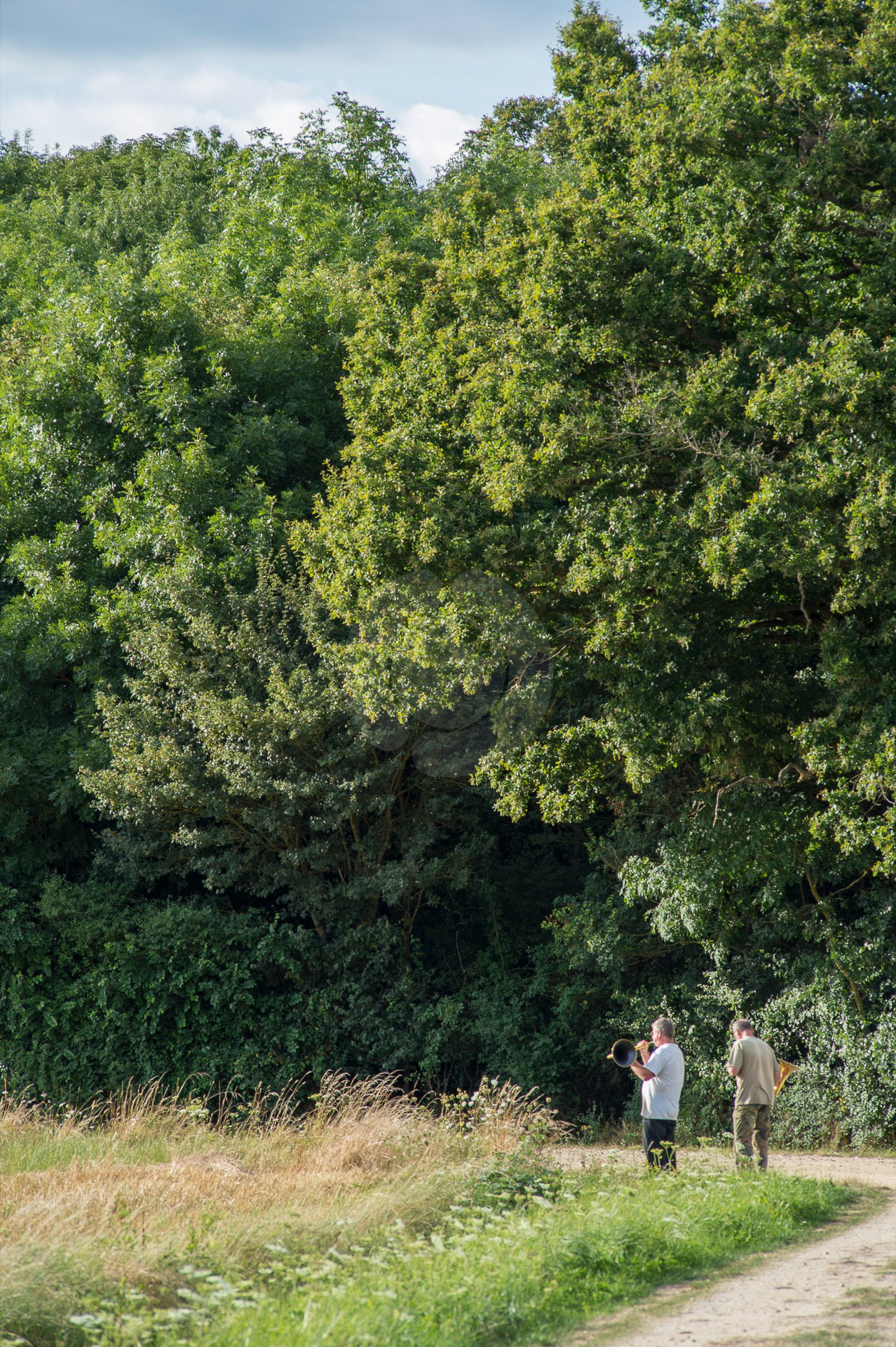 Deux sonneurs de cor répètent au bout du chemin à la Clémenderie